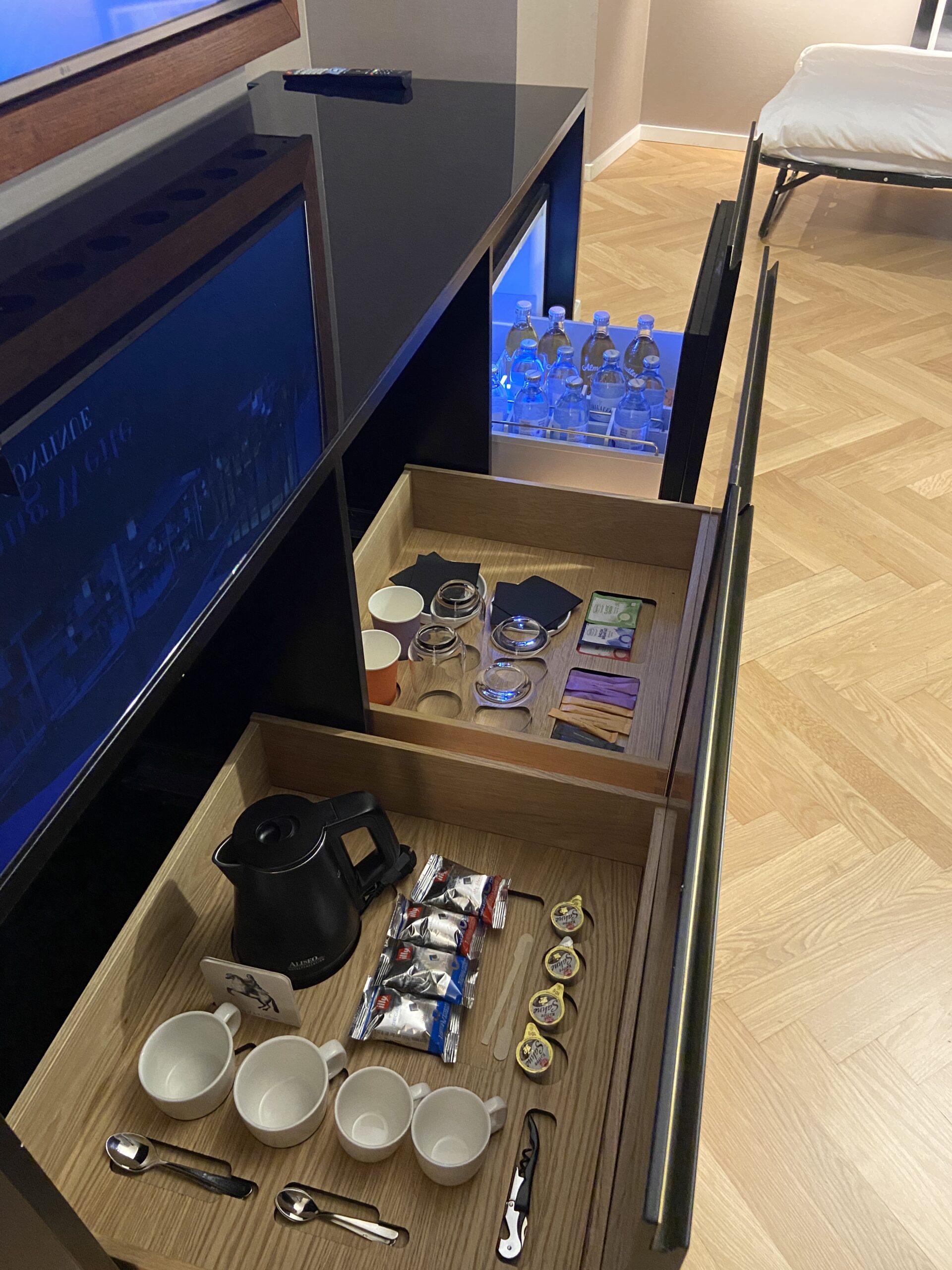 alarge mini fridge stocked with complimentary snacks and drinks