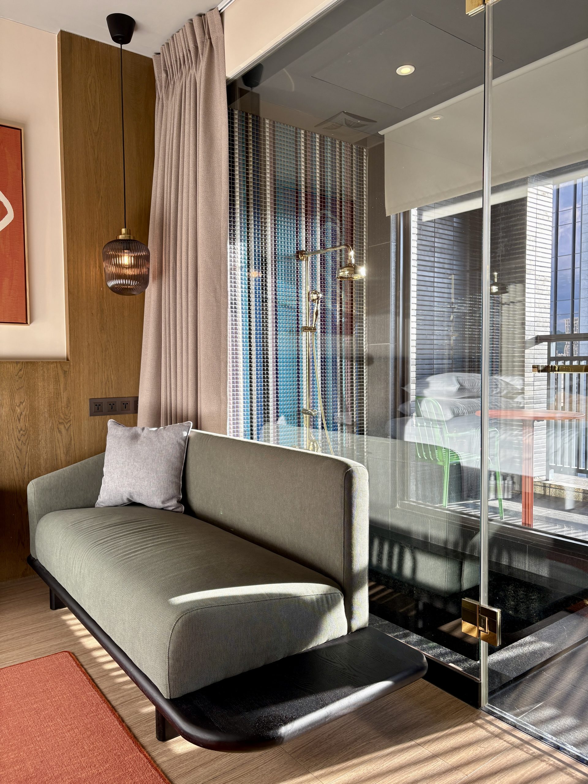 Corner lounging sofa next to the glass shower room
