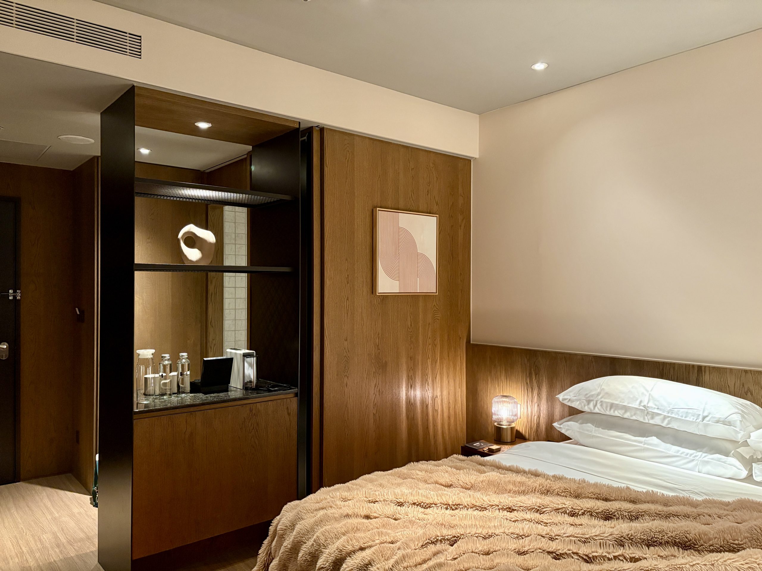 Vertical closet and coffee station are next to the toilet room by the entrance.