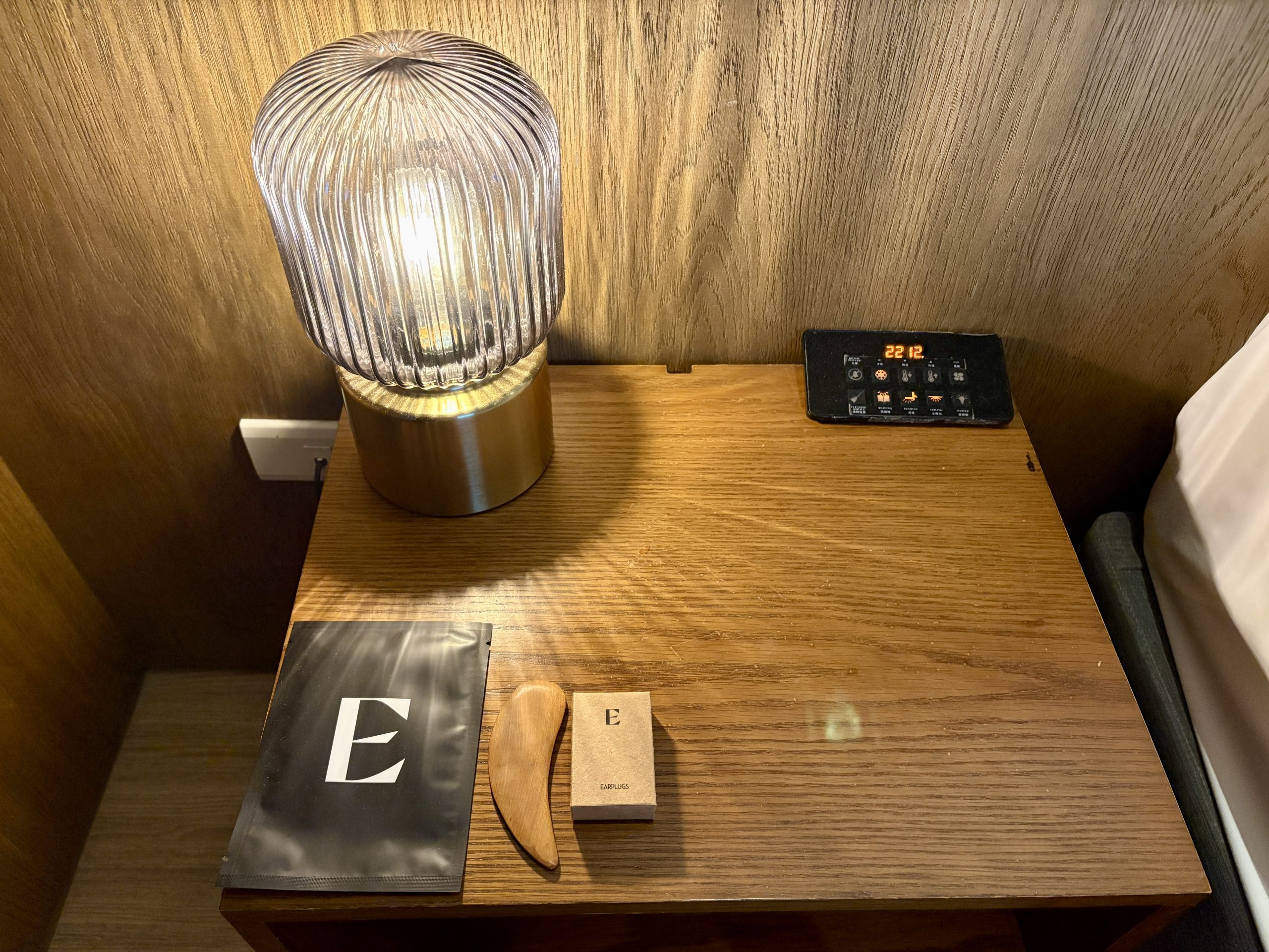 Face mask, gua sha tool, and air plugs on the bedside table