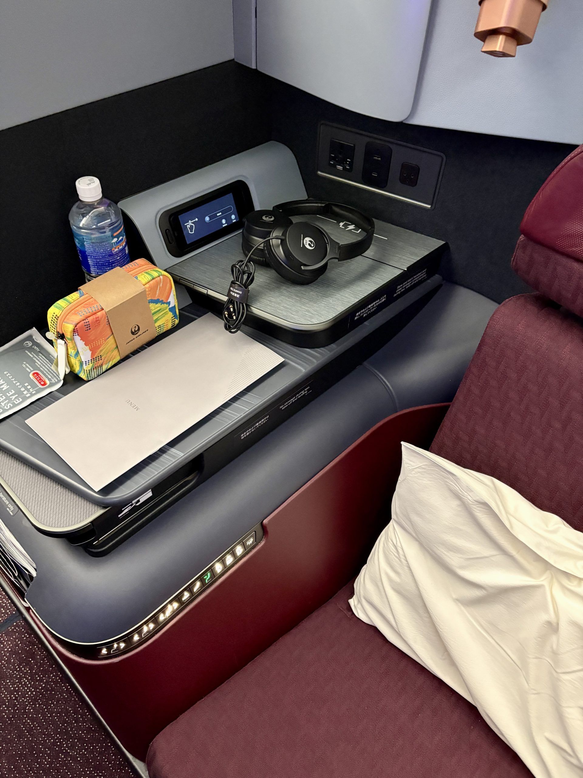 Welcome amenities, water, eye mask, menu and headphones come ready with the seat.