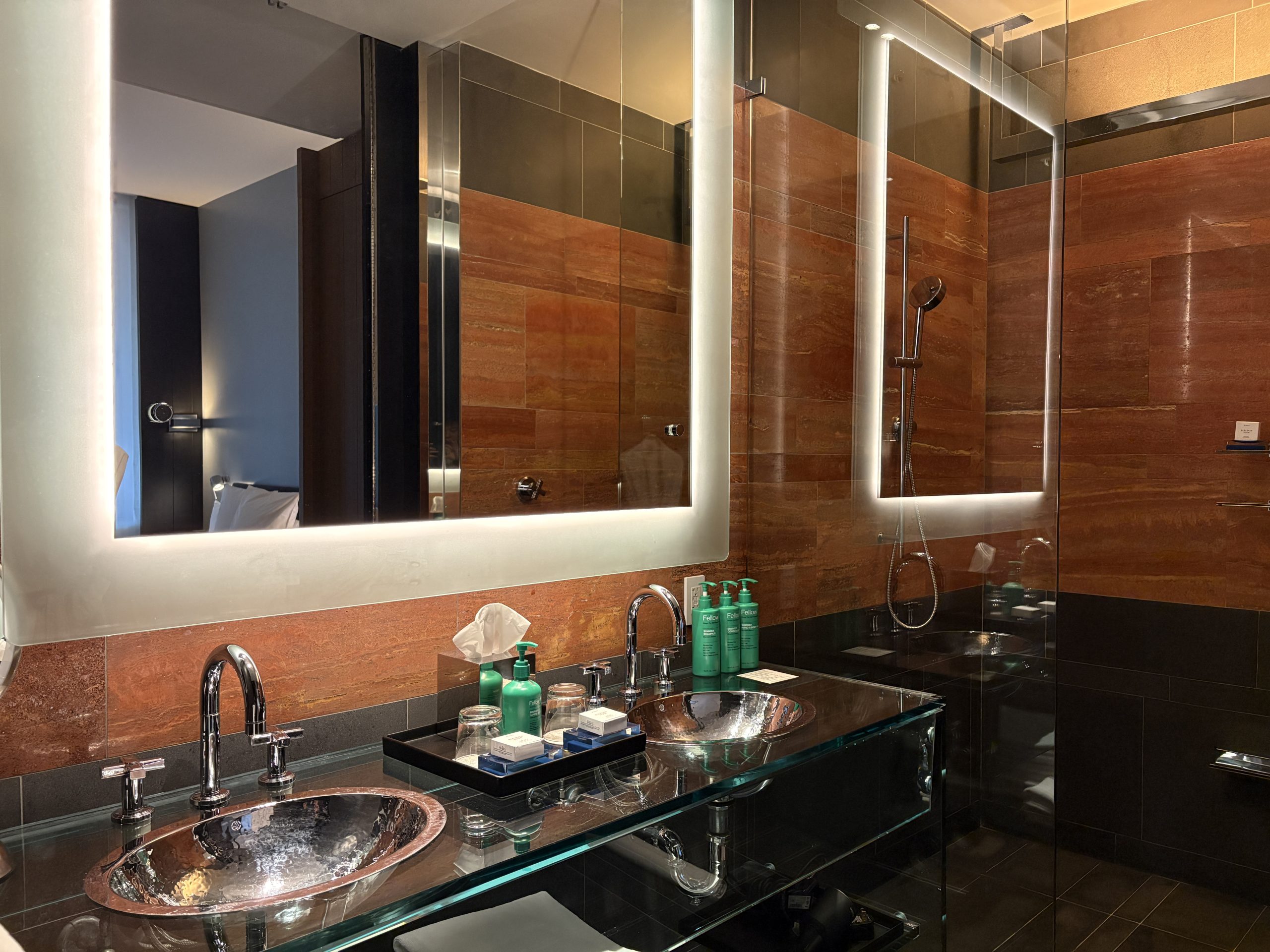Glass vanity with metallic sinks in the modern bathroom