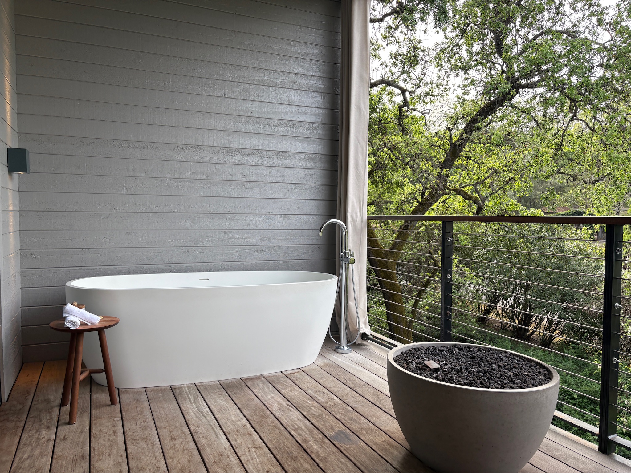 Serene outdoor patio with a bathtub and fire pit