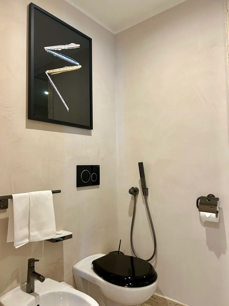 Park Hyatt Milan bathroom corner with a toilet, a bidet, and framed artwork