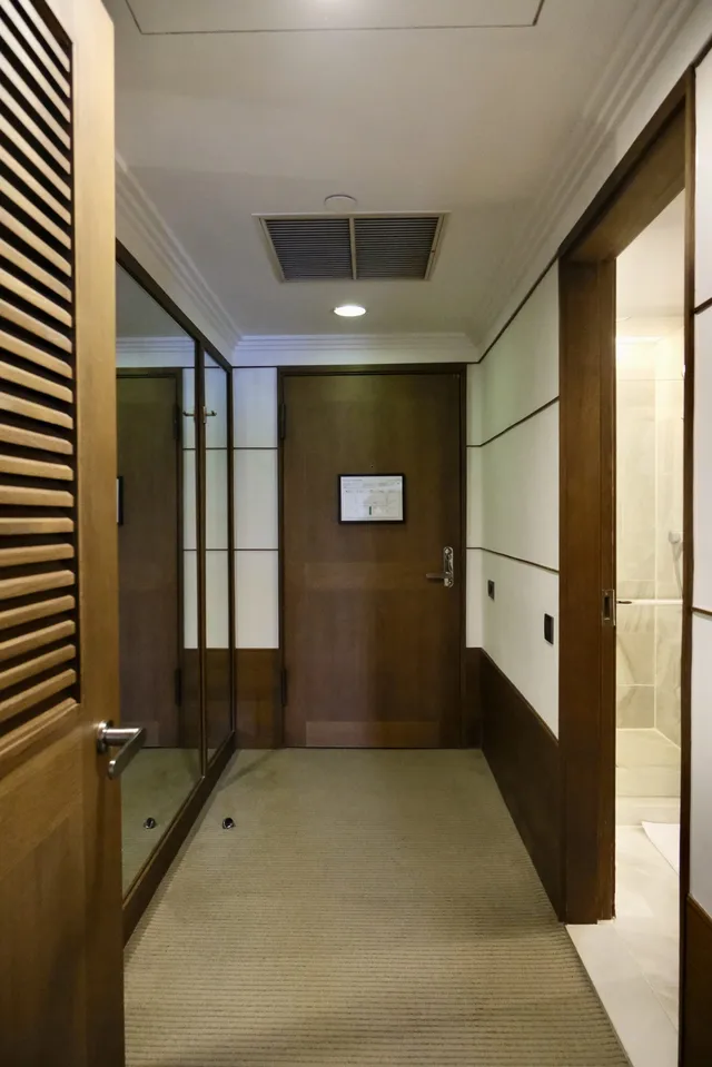 Entrance corridor with bathroom on one side and mirror on the other